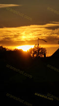 Sunset Behind Trees with Flag on Pole