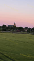 Church with Surrounding Trees and Houses at Sunset