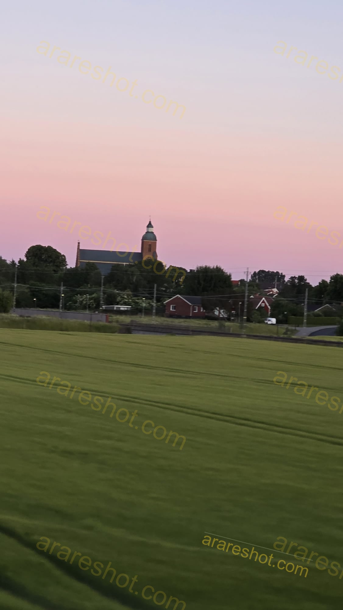 Church with Surrounding Trees and Houses at Sunset