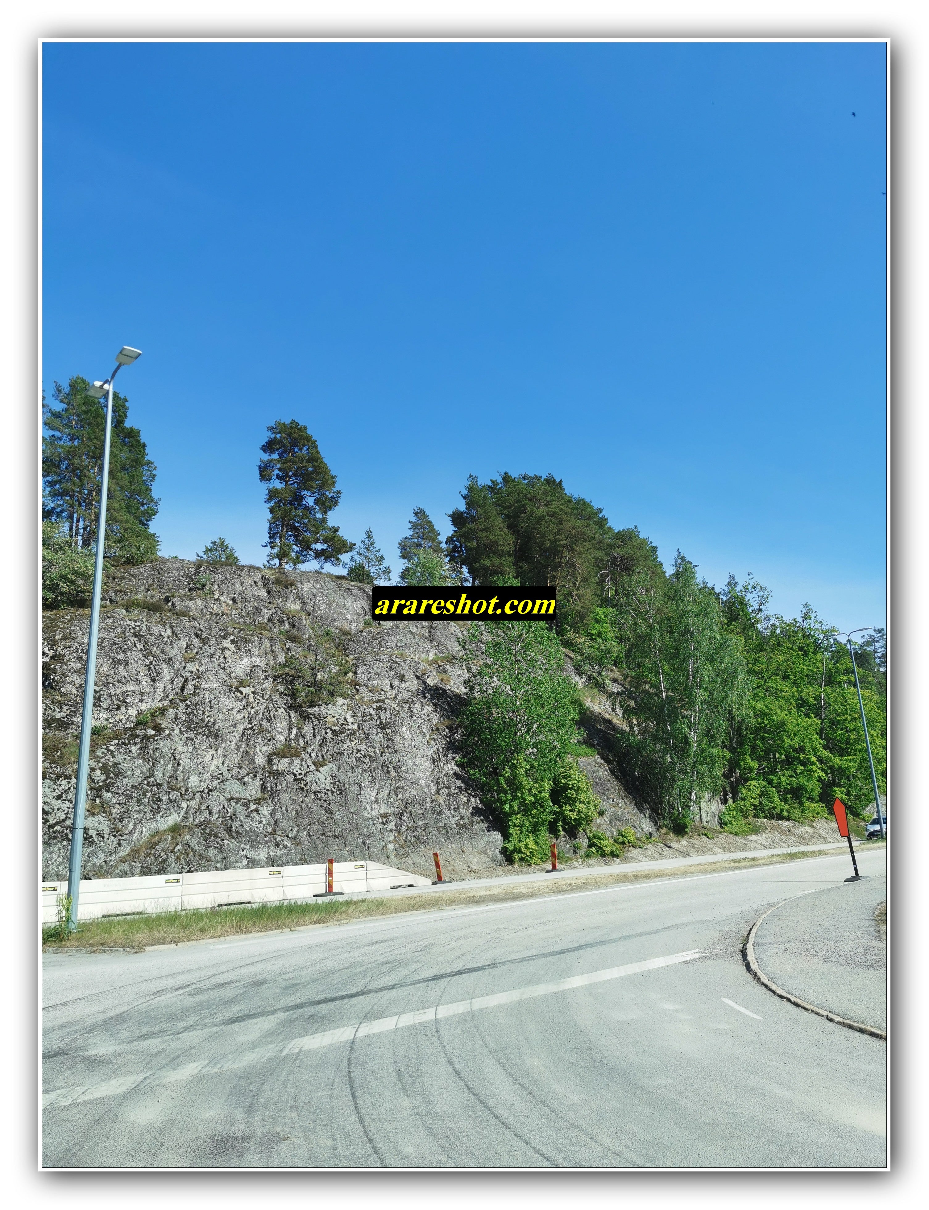Curved Road Beside Rocky Hillside