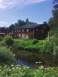 Red House by River with Green Vegetation