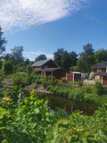 Red Houses Near Small River with Greenery
