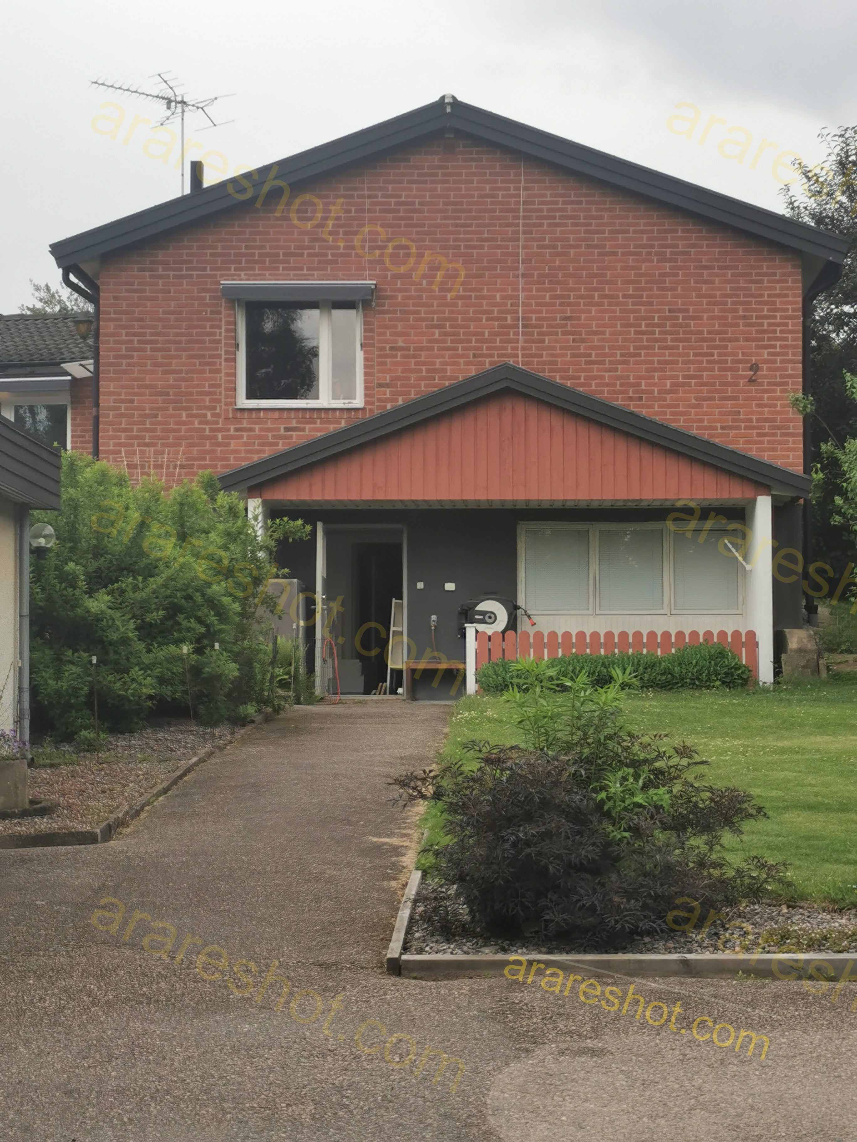 Two-Story Brick House with Front Lawn and Driveway