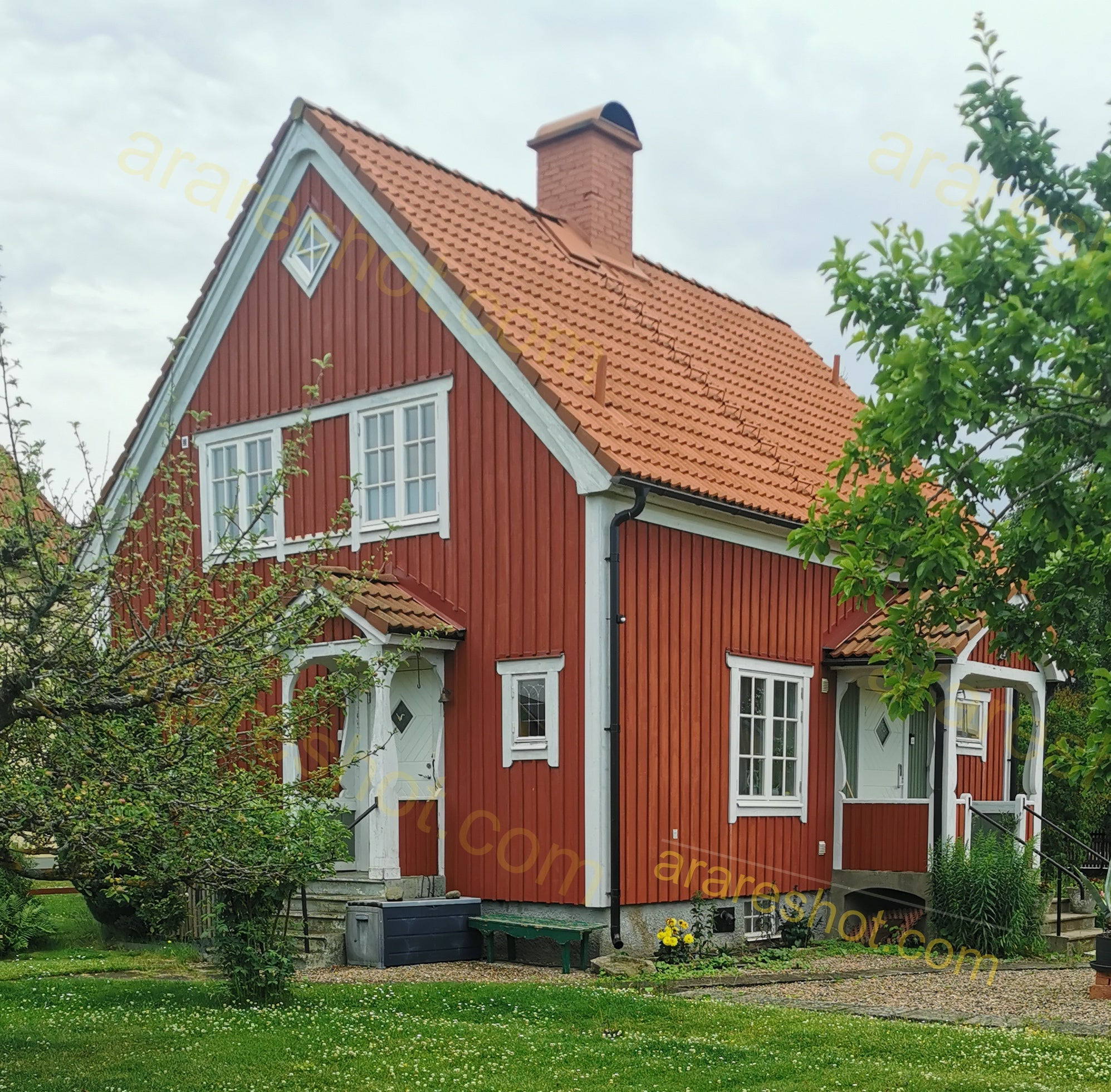 Red Wooden House with White Trim and Garden