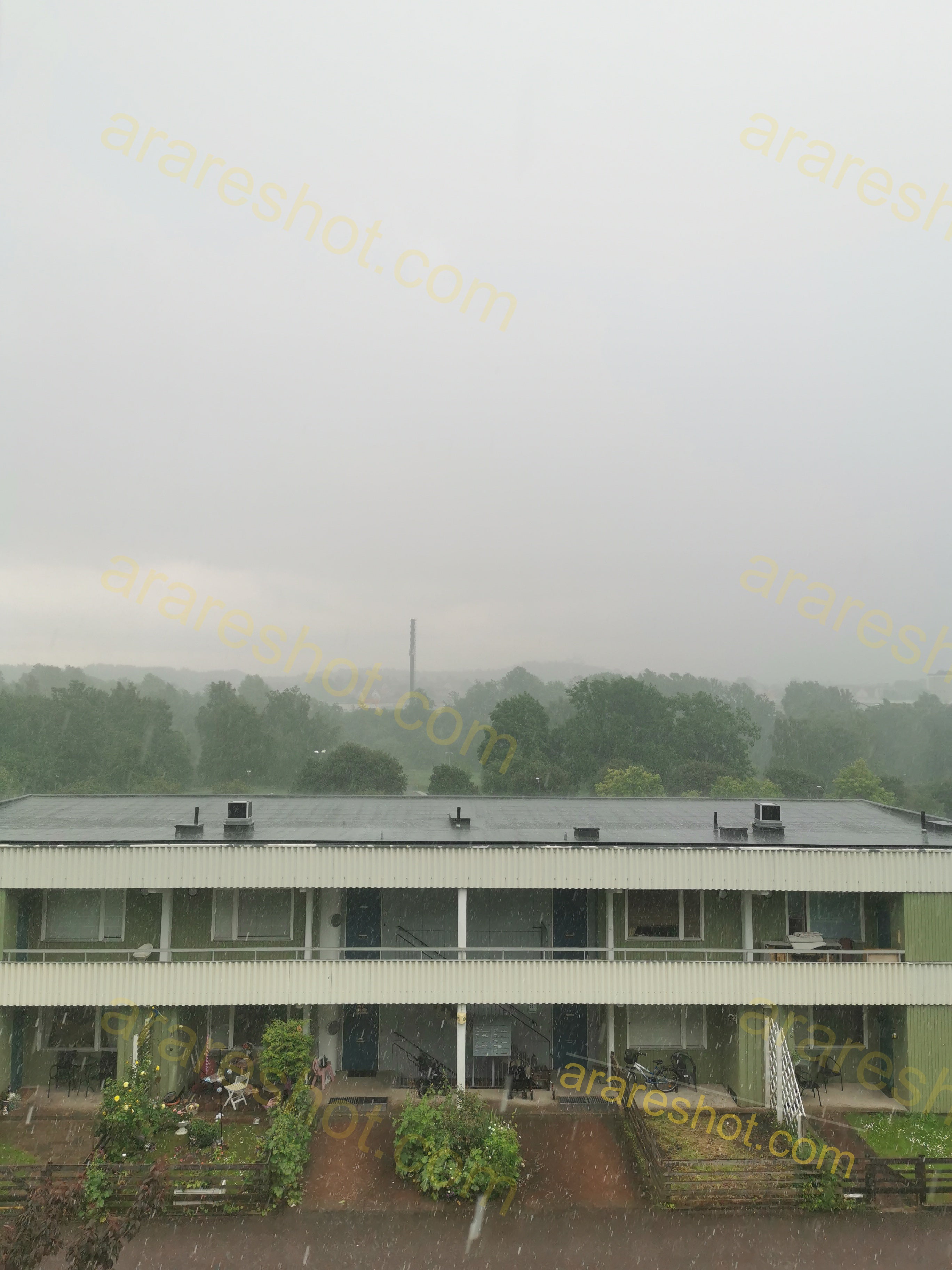 Apartment Building with Garden and Trees in Rain