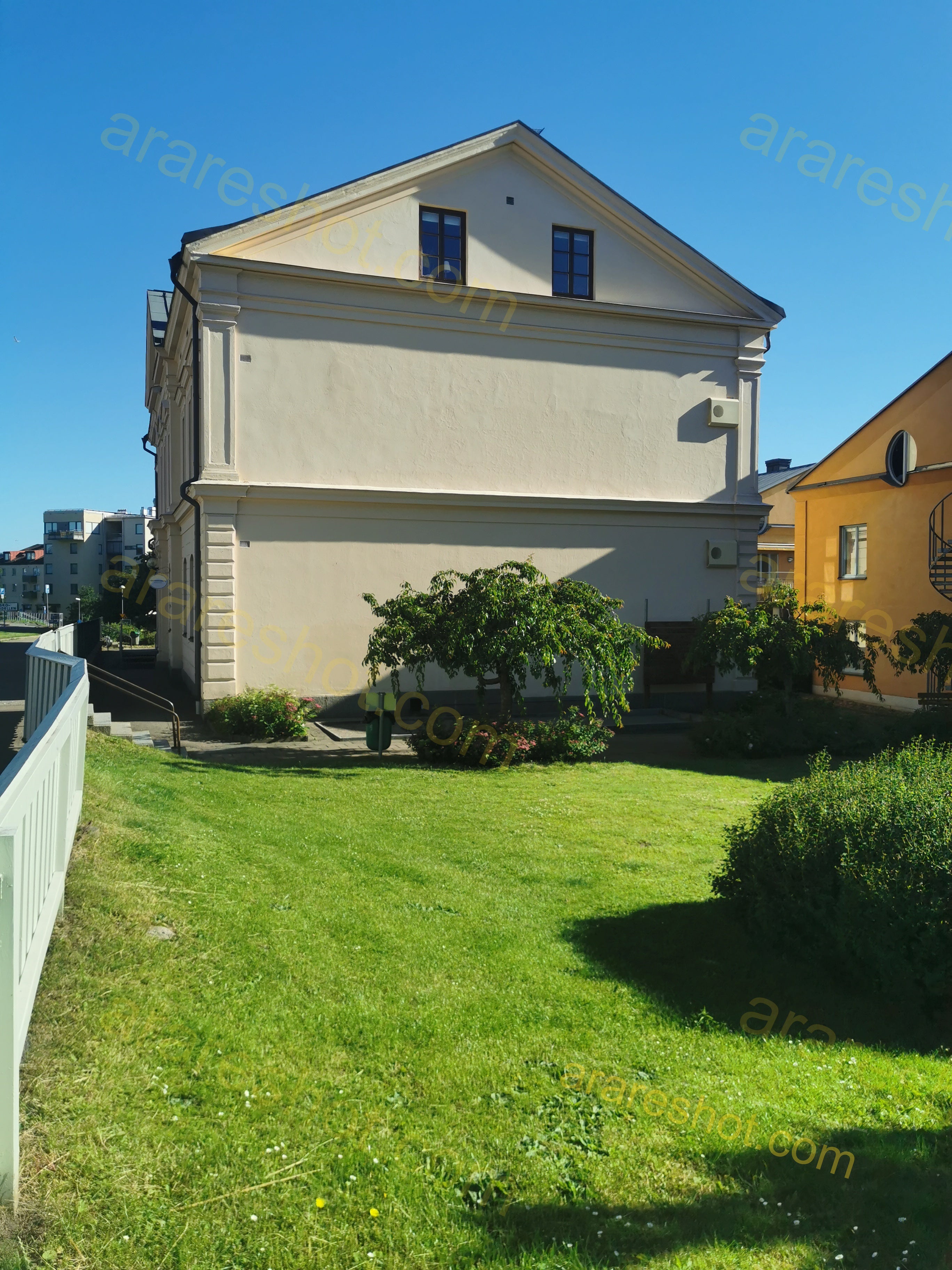 White Building with Green Lawn and Trees