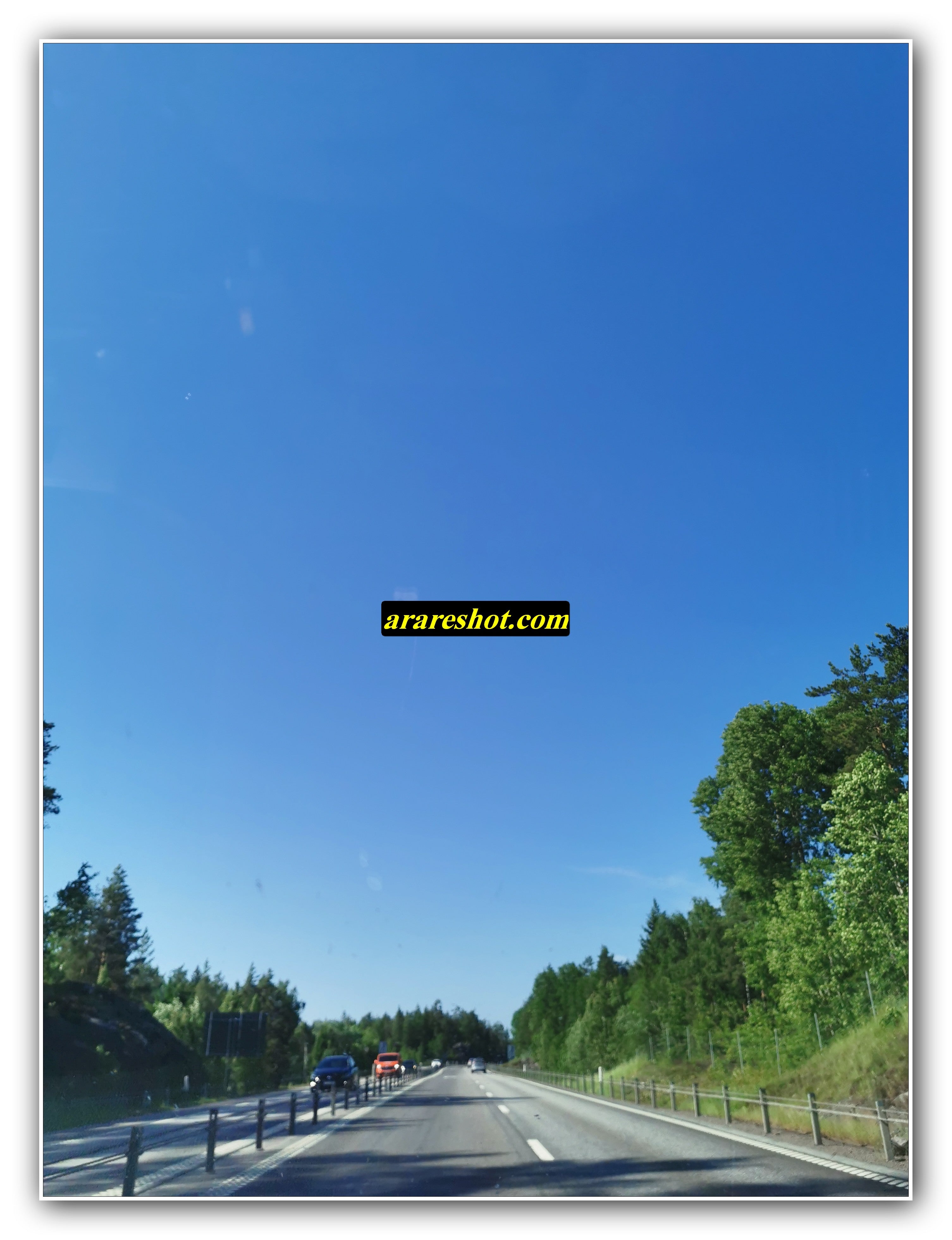 Sunny Dual-Lane Highway Surrounded by Green Forest