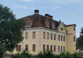 Large Beige Building with Brown Roof and Multiple Windows