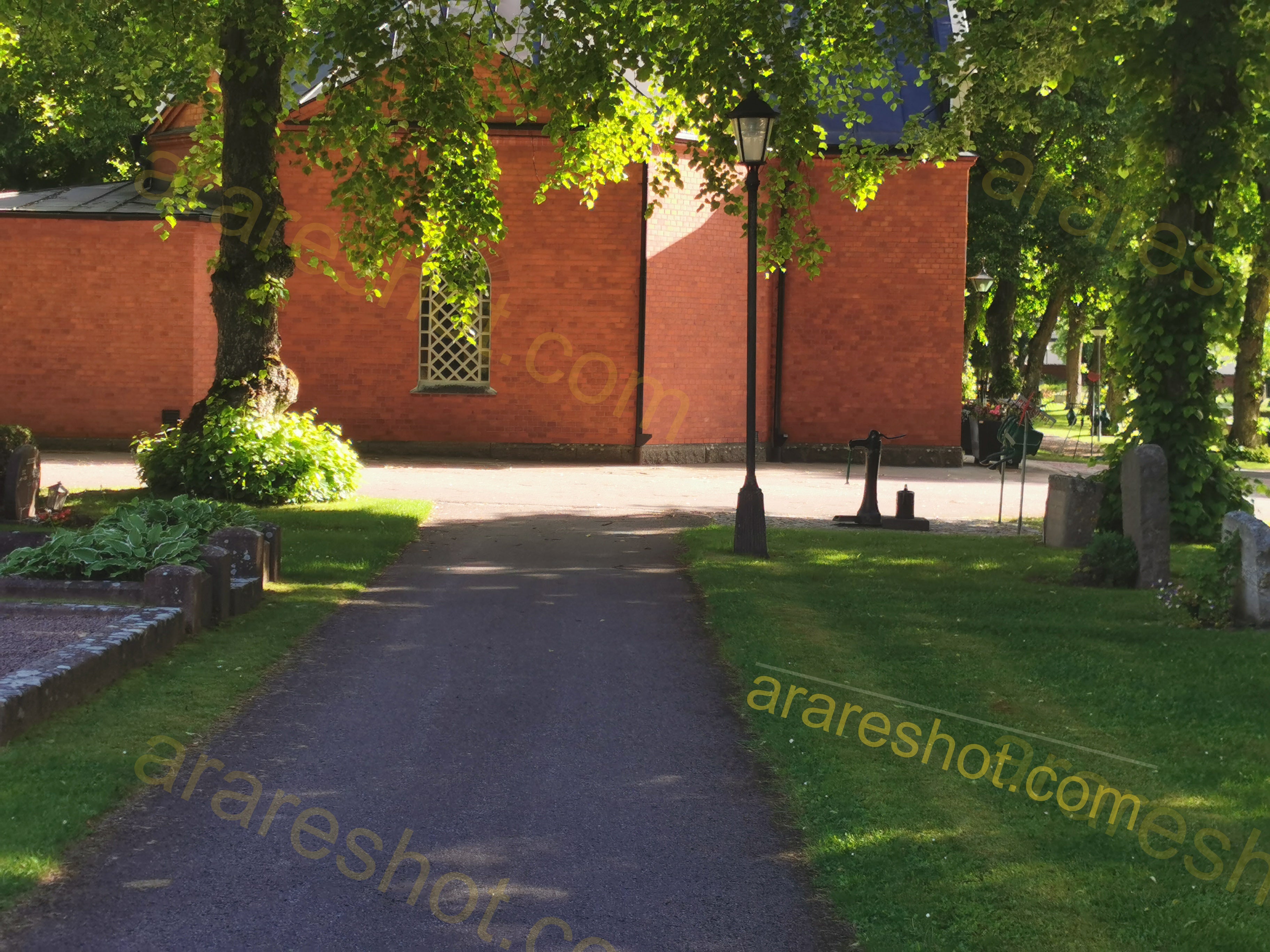 Paved Path with Trees and Grass near Brick Building