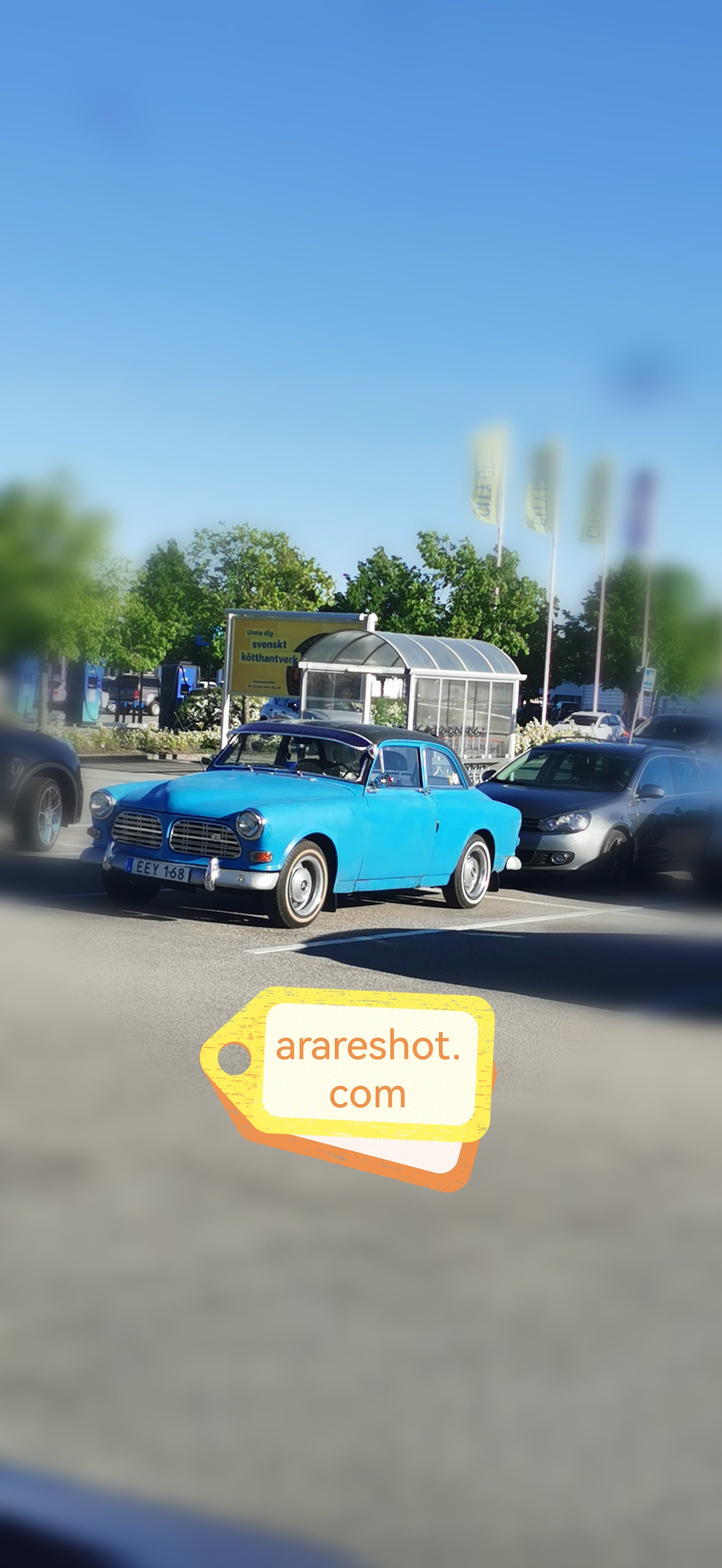 Blue Vintage Car in Modern Parking Lot