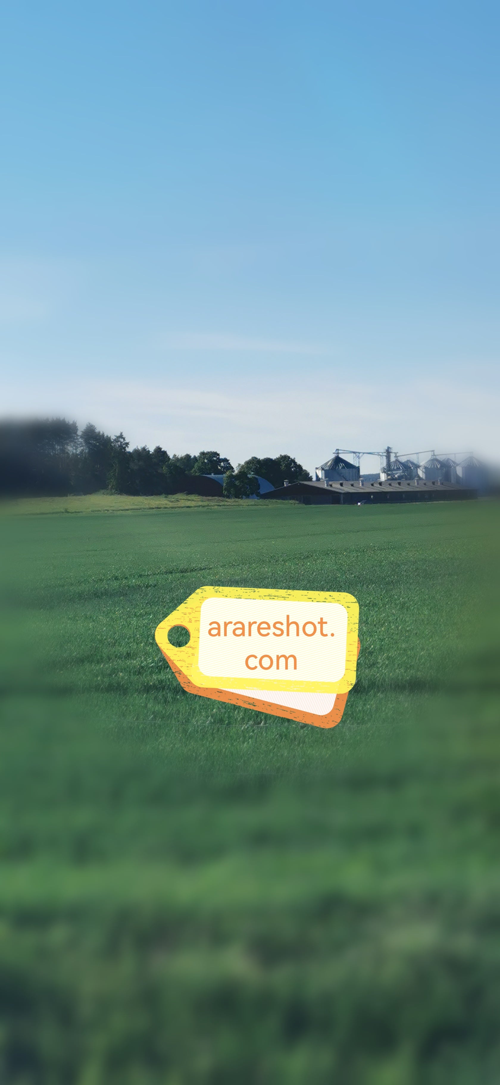 Green Farmland with Silos  Under Clear Sky