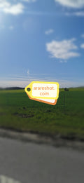 Rural Road Beside Green Farmland Under Blue Sky